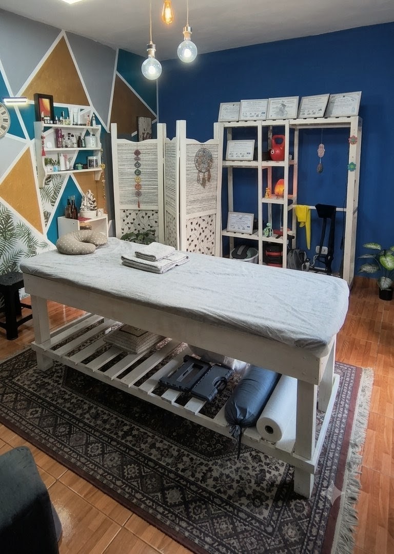 Serene massage therapy treatment room in San Miguel, clean professional wooden massage table with crisp beige towels